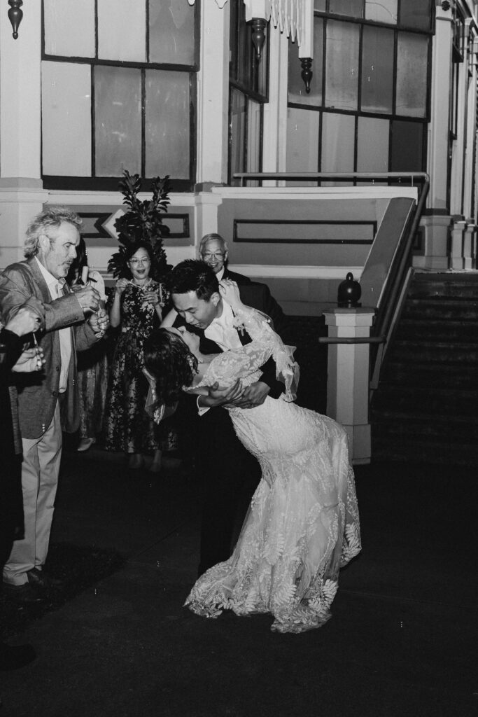 Couple shares a kiss as they leave their wedding celebration