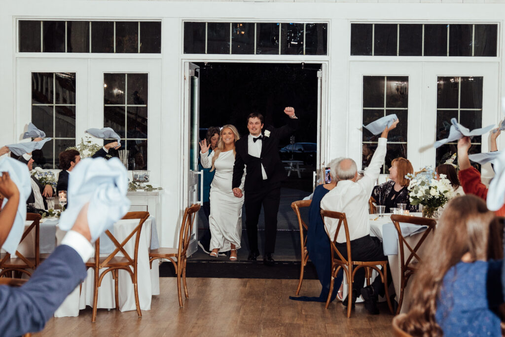 Unique entrance to wedding reception with waving napkins